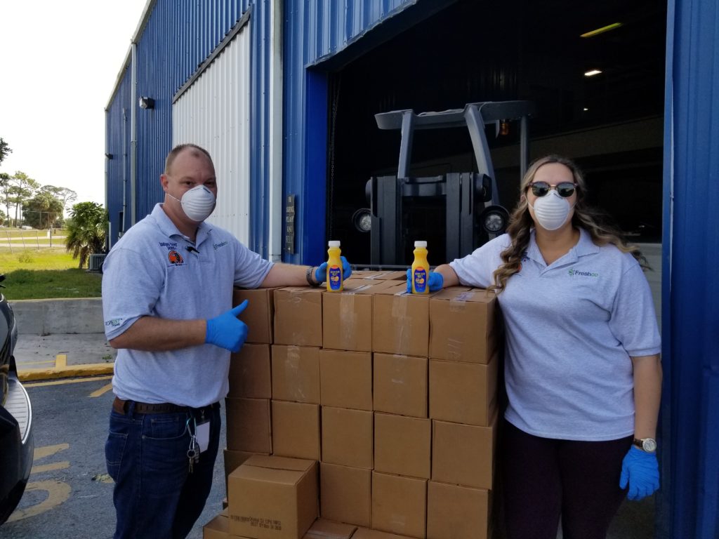 Two Indian River employees pose with boxes and juice